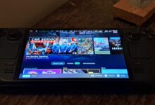 Valve Steam Deck OLED handheld showing the home screen on its front display