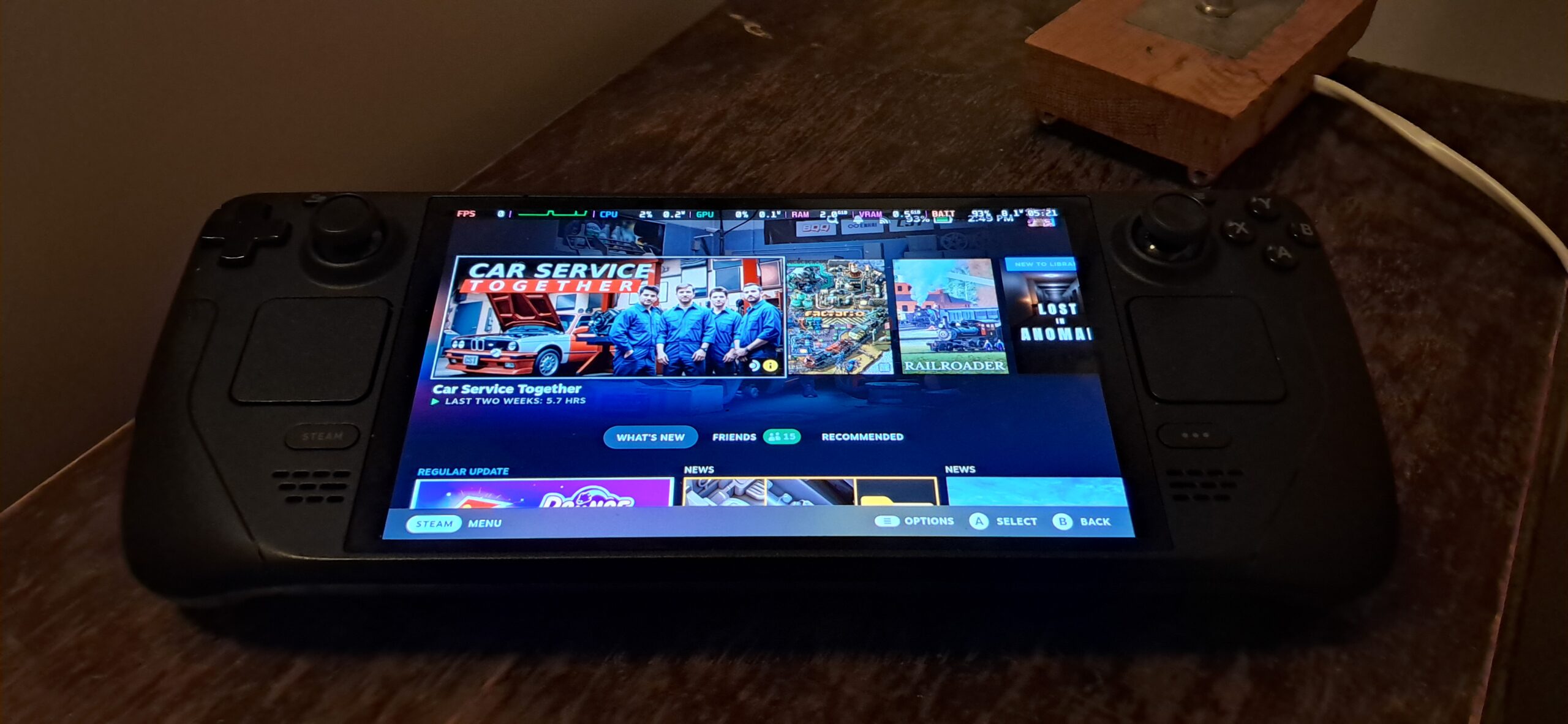 Valve Steam Deck OLED handheld showing the home screen on its front display